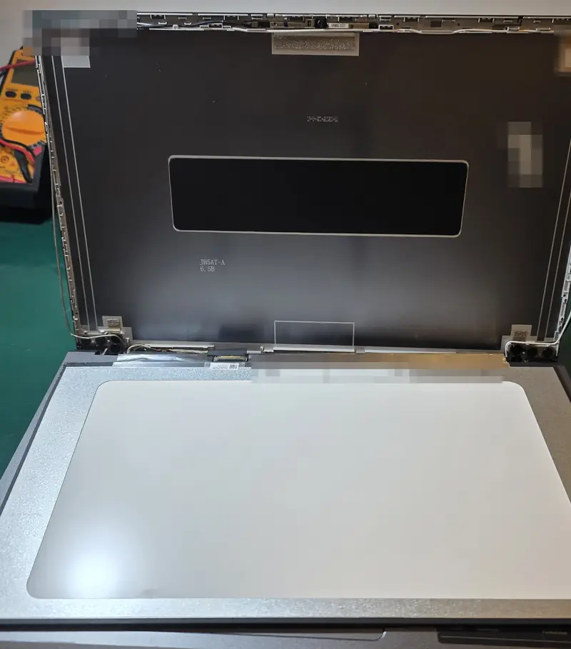 Tampa do Acer Aspire A15-51M aberta durante a troca, com o painel LCD novo apoiado sobre a base