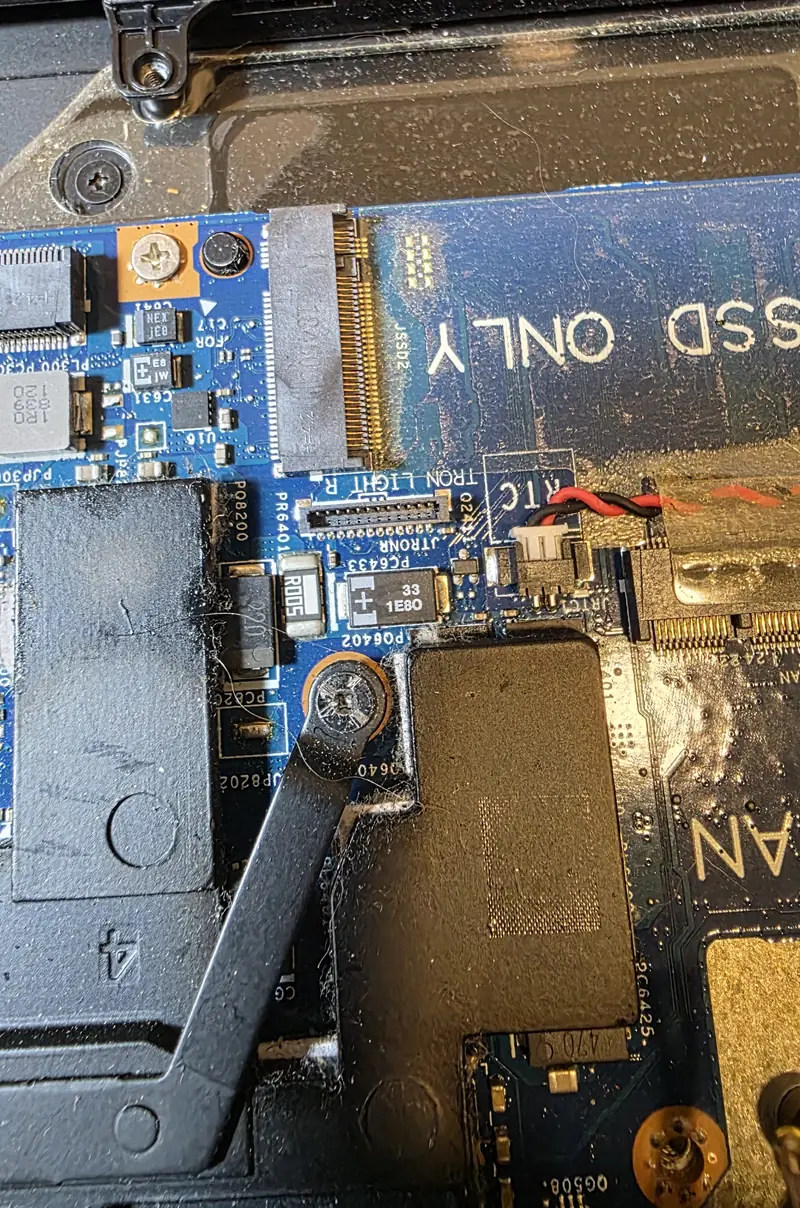 Parafuso de fixação do dissipador do Alienware 17 R5 perto do slot de SSD e de componentes da placa
