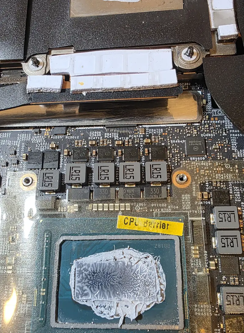 Processador do Alienware m16 R1 com pasta térmica antiga espalhada e a etiqueta CPU Barrier da moldura de proteção