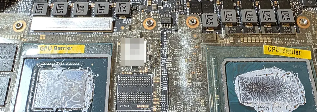 Placa-mãe do Alienware m16 R1 aberta, com pasta térmica ressecada sobre a GPU e o processador e as barreiras de metal líquido ao redor