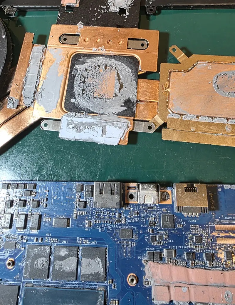 Dissipador do Alienware x17 R1 com pasta térmica em excesso transbordando das bases e placa com pasta sobre os chips de memória de vídeo