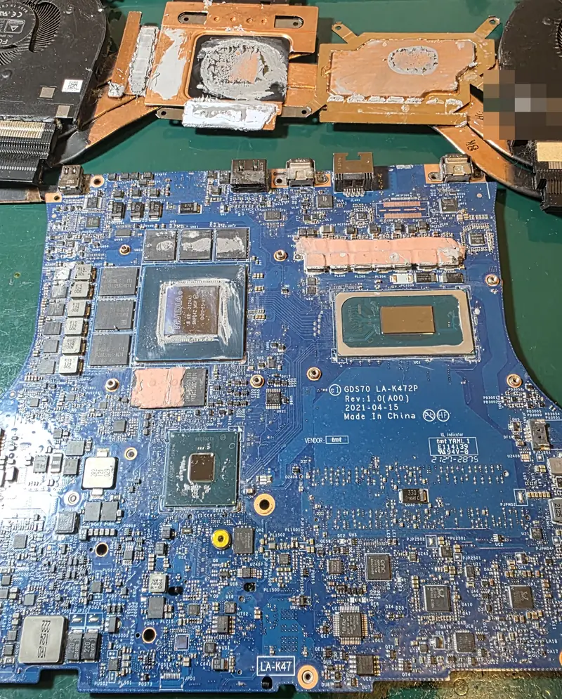 Placa-mãe do Alienware x17 R1 fora da carcaça, com resíduos de pasta térmica em volta do processador e da GPU antes da limpeza