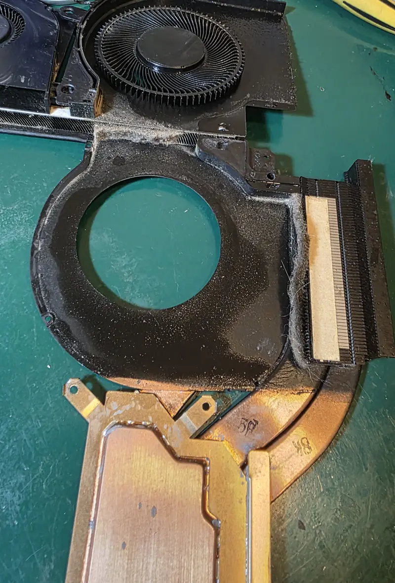 Carcaça da ventoinha do Alienware x17 R1 aberta, com poeira compactada em forma de feltro junto às aletas do dissipador
