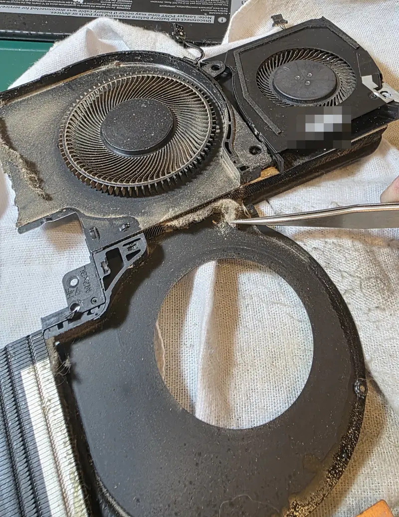 Ventoinhas do Alienware x17 R1 abertas sobre um pano, com poeira nas pás e na carcaça, durante a limpeza