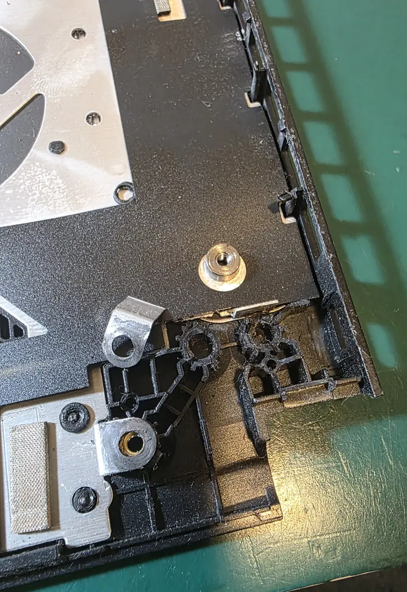 Palm rest do Asus TUF Gaming A15 com as fixações da dobradiça danificadas e as buchas metálicas soltas