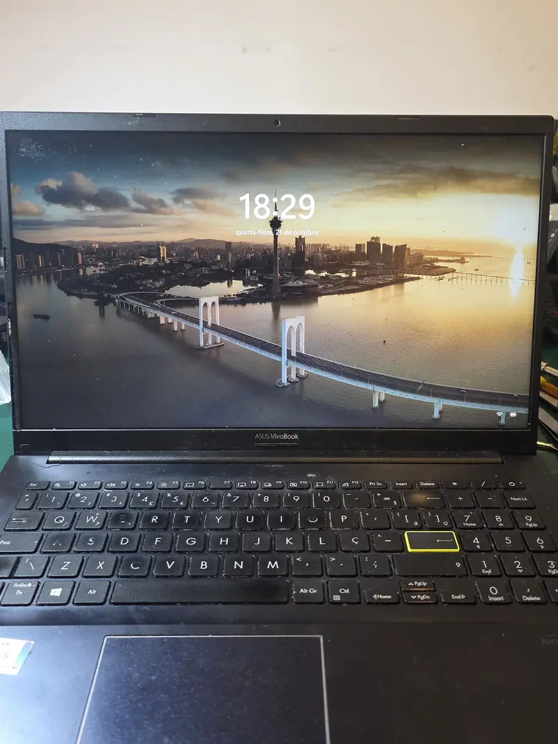 Asus Vivobook X513EA montado, com a moldura presa, ligado na tela de bloqueio do Windows