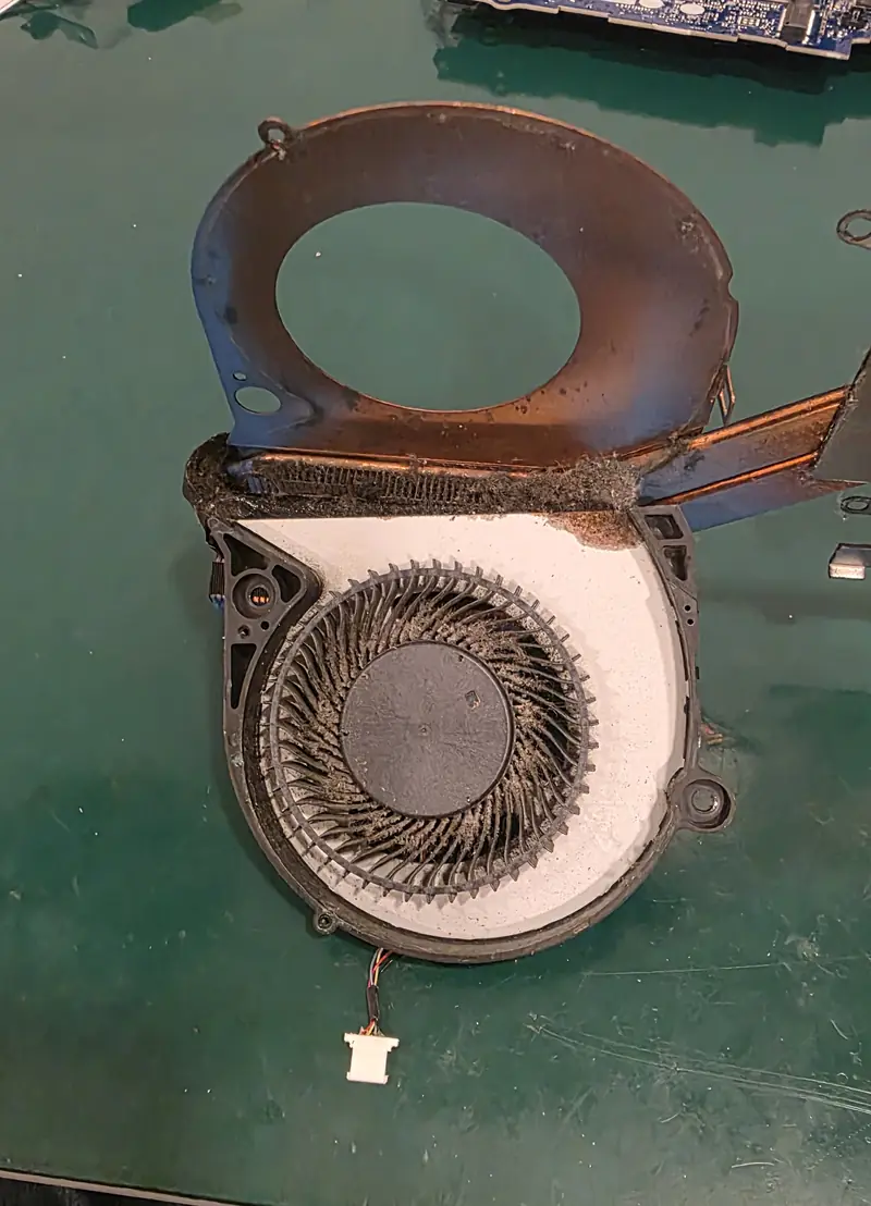 Ventoinha do Dell G7 7588 aberta, com poeira compactada nas pás e na saída de ar do dissipador