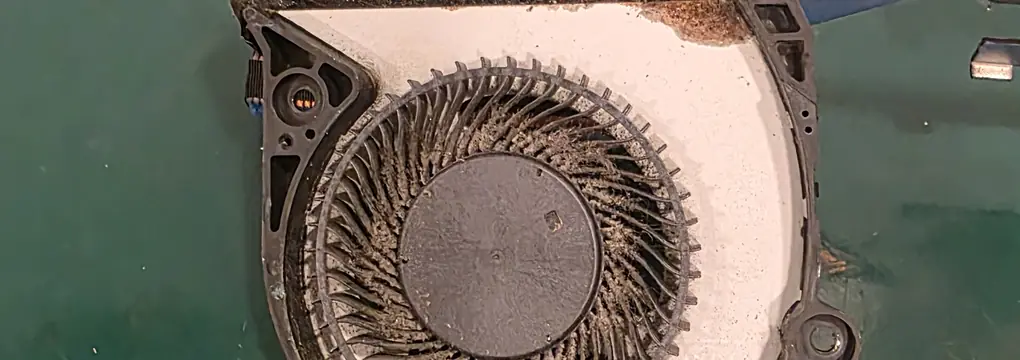 Ventoinha do Dell G7 7588 aberta, com poeira compactada nas pás e na saída de ar do dissipador