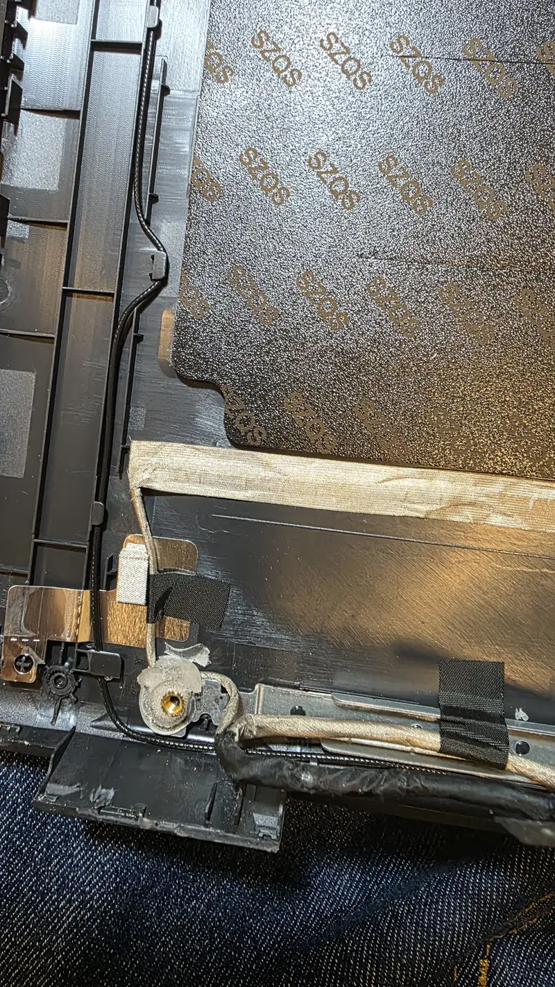 Parte interna da tampa antiga do Dell Latitude 3520 com o painel e a fixação da dobradiça