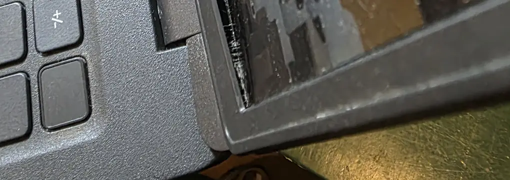 Moldura da tela do Dell Latitude 3520 soltando da tampa na lateral da dobradiça