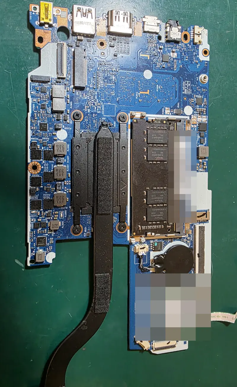 Placa-mãe do Lenovo IdeaPad 3 fora do notebook, com dissipador, memória e placa Wi-Fi, sobre a bancada