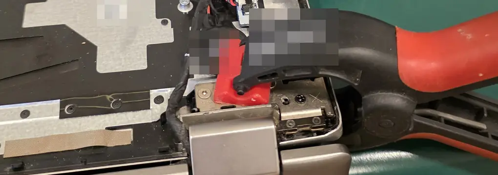 Palm rest do Lenovo Yoga 520 aberto, com um grampo prendendo a carcaça na região da dobradiça direita durante a cura da resina
