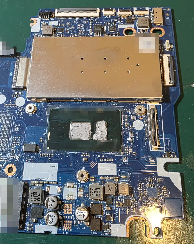 Placa-mãe do Lenovo Yoga 520 fora da carcaça, com pasta térmica sobre o processador, durante a limpeza completa