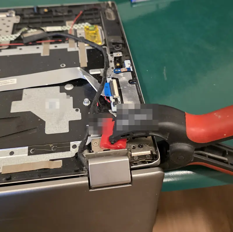 Palm rest do Lenovo Yoga 520 aberto, com um grampo prendendo a carcaça na região da dobradiça direita durante a cura da resina