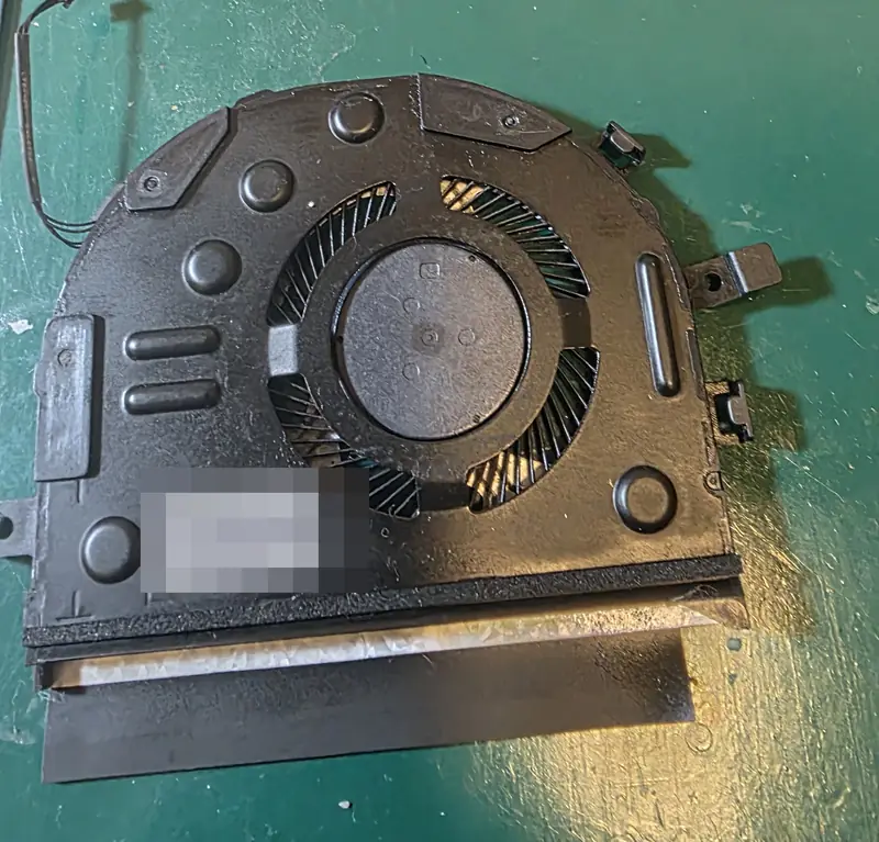 Ventoinha do Lenovo Yoga 520 separada do dissipador de cobre sobre a bancada, durante a limpeza completa