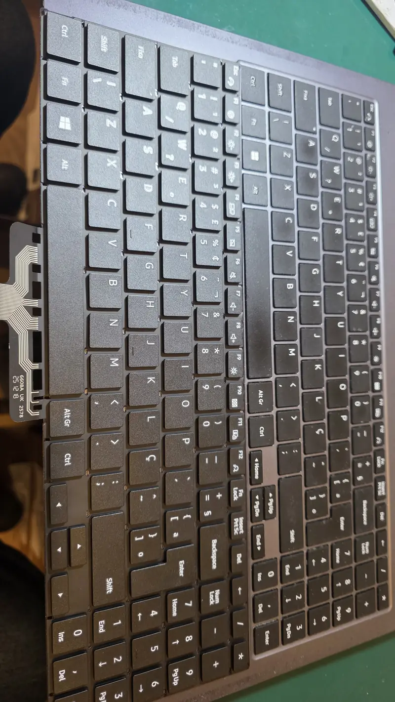 Teclado novo do Samsung NP550XDA, com o flat de conexão, apoiado ao lado do palm rest
