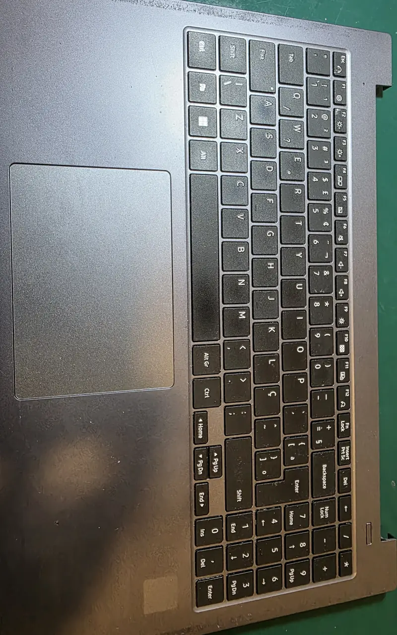 Palm rest do Samsung NP550XDA com o teclado preso por solda plástica, visto por cima